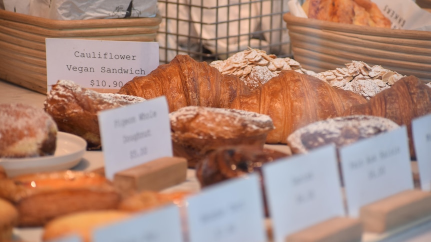 Bakery goods on bench, croissants very visible with prices next to them