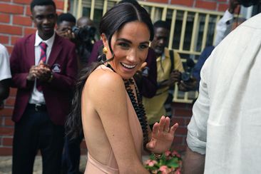 Meghan Markle gestures as she and Prince Harry visit children at the Lights Academy in Abuja, Nigeria, Friday, May 10, 2024.   