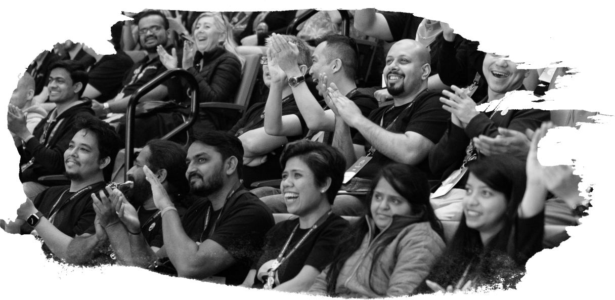 A black and white photograph of excited, applauding attendees in the audience at a WordPress event.