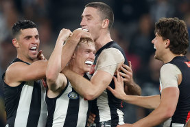 Collingwood’s Joe Richards, middle, is mobbed by his teammates after kicking his first AFL goal.