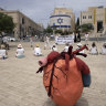 Women activists hold a silent protest with placards in Arabic, Hebrew and English calling for a ceasefire in the Gaza Strip and safety, freedom and equality for Israelis and Palestinians, outside of the walls of the Old City of Jerusalem on Friday.