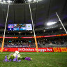 Flowers are laid for Cam McCarthy by Nat Fyfe and Alex Pearce.