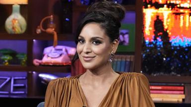 Jessel Tank, a woman wearing a brown top, sitting on a blue softa, looking at the camera with a smile. Behind her is a sparkly background, with a letter arrangement spelling out "maze", books, a teddy bear and a landline phone.