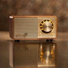 an old fashioned radio sitting on top of a shiny table next to a glass surface