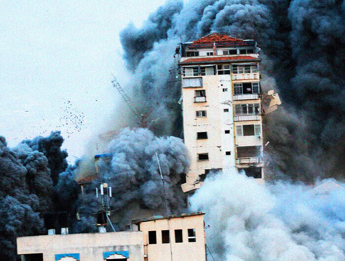 A tower in Gaza is bombed by an Israeli missile.