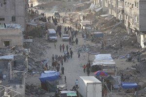 Palestinians walk through the debris after an Israeli air and ground offensive in Khan Younis, southern Gaza Strip, Wednesday, May 15, 2024.