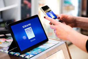 A person using a smartphone to make a QR code payment, Brussels, Belgium