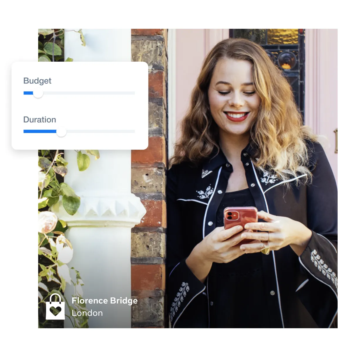 woman outside leaning on a wall smiling while looking at her phone