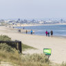 Walkers enjoying a stroll on Aspendale beach.