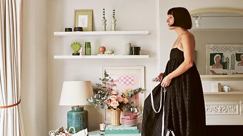 Woman holding measuring tape by window at home