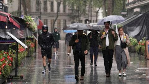 People in the rain with umbrellas