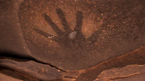 hand on cave getty images