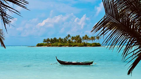 Boat in blue water in front of Kalpeni Island, Lakshadweep