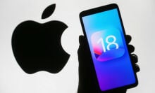 ios 18 logo on a smartphone in front of a background that shows the apple logo