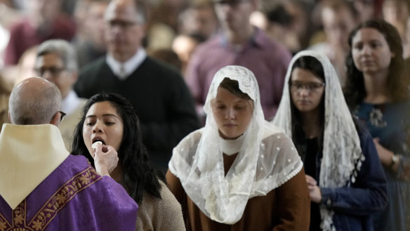 People receive communion during Catholic Mass at Benedictine College in Kansas.