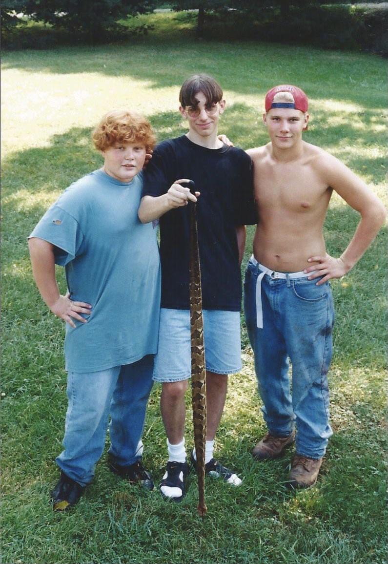 r/blunderyears - What my suburban self wore going squirrel hunting with my Kentuckian cousins for the first time. I saved my cousin’s life (shirtless one) when I stopped him from stepping on this 4 foot long rattlesnake.