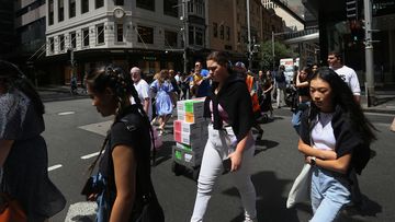 Pedestrians move across Market Street in Sydney, Australia. 