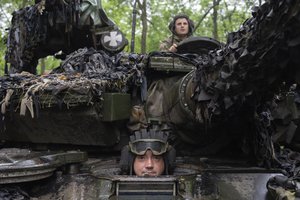 Ukrainian soldiers on a tank look on as they ride along the road towards their positions near Bakhmut, Donetsk region, Ukraine, Tuesday, May 23, 2023.