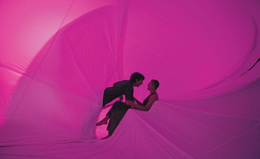 scene from Chunky Move, ‘You, Beauty’, with dancers embracing within folds of billowing pink fabric  