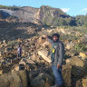 People gather at the site of a landslide in Maip Mulitaka in Papua New Guinea’s Enga Province.