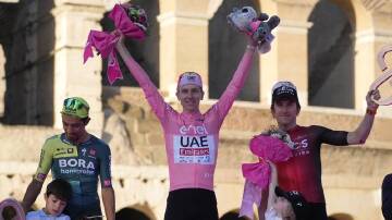 Tadej Pogacar (centre) celebrates alongside Daniel Felipe Martinez (left) and Geraint Thomas. (AP PHOTO)