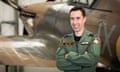 Sqn Ldr Mark Long smiling in front of a Spitfire