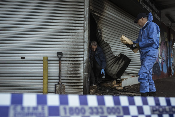 Police and arson investigators on the scene at another tobacco store arson attack in Hadfield last August.