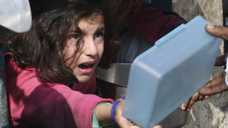 Palestinians line up for food amid the Israeli air and ground offensive.