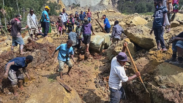 Villagers search through a landslide in Pogera village, in the Highlands of Papua New Guinea.
