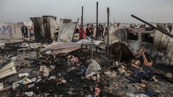 Palestinians look at the destruction after an Israeli strike where displaced people were staying in Rafah, Gaza Strip, Monday, May 27, 2024. Palestinian health workers said Israeli airstrikes killed at least 35 people in the area. Israel’s army confirmed Sunday’s strike and said it hit a Hamas installation and killed two senior Hamas militants. (AP Photo/Jehad Alshrafi)