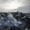 Palestinians look at the destruction after an Israeli strike where displaced people were staying in Rafah.