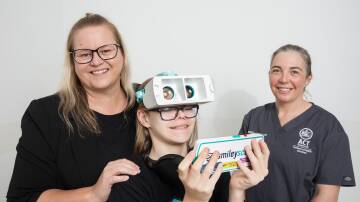 Dr Alison Lally, right, introduces Annabell Fenton and her neurodivergent son Max, 12, to a virtual reality headset at Canberra Hospital. Picture by Sitthixay Ditthavong