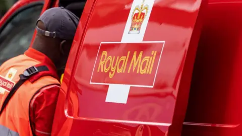 Royal Mail worker looking at their van