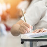 Exam with school student having a educational test, thinking hard, writing answer in classroom for  university education admission and world literacy day concept