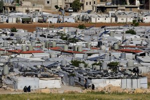 File - Syrian refugees sit outside their tents near the gathering point where other refugees prepare to back home to Syria as a part of a voluntary return, in the eastern Lebanese border town of Arsal, Tuesday, May 14, 2024. Hundreds of Syrians refugees left a remote northeastern Lebanese town back to Syria in a convoy, amid a surge in anti-refugee sentiment in the small, crisis-hit country. Lebanese officials for years has urged the international community to resettle the refugees in other countries or help them return to Syria.