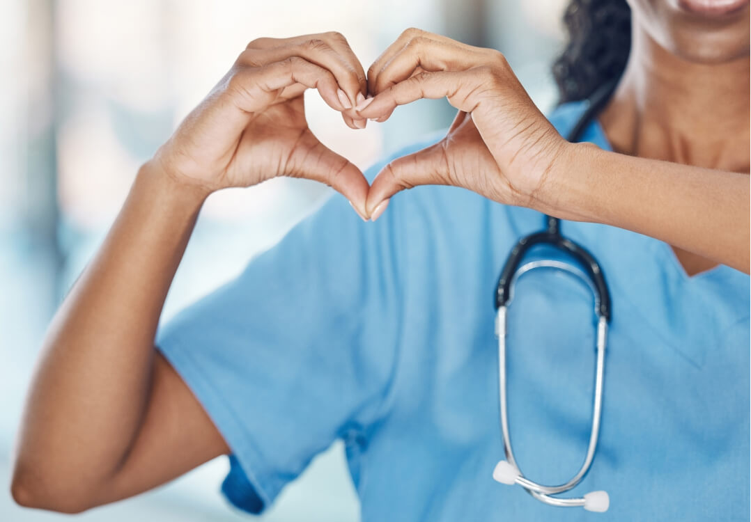 healthcare professional using hands to make heart shape