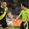 A wired-up umpire explains a decision to Dustin Martin.