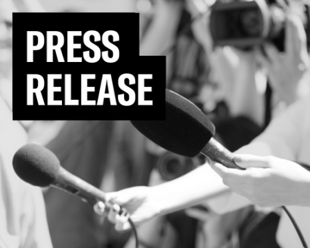 a black and white photo of hands holding microphones at a press conference