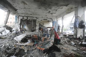 Palestinians look at the aftermath of the Israeli strike on a U.N.-run school that killed dozens of people in the Nusseirat refugee camp in the Gaza Strip, Thursday, June 6, 2024. (AP Photo/Abdel Kareem Hana)