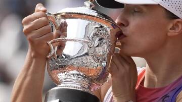 Poland's Iga Swiatek kisses the trophy after winning the French Open for the fourth time in Paris. (AP PHOTO)