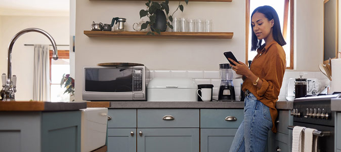 Woman using Phone in Kitchen