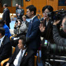 Chinese officials try to block cameras from filming Chinese-born Australian journalist Cheng Lei (covered).