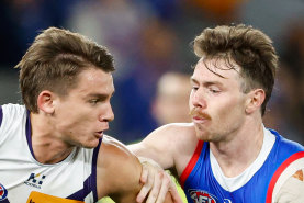 Caleb Serong of the Dockers is tackled by Lachlan Bramble.