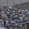 Muslim pilgrims use umbrellas to shield themselves from the sun as they arrive to cast stones at pillars in the symbolic stoning of the devil, the last rite of the annual haj.