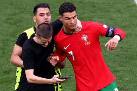 Cristiano Ronaldo tries to get away from a pitch invader.