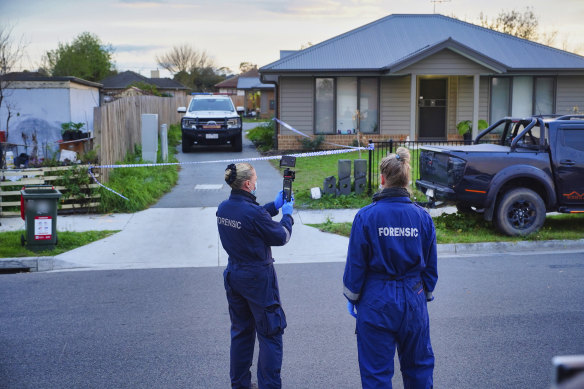 Police are seen outside the scene where two men, a woman and a teenage boy, were located deceased.