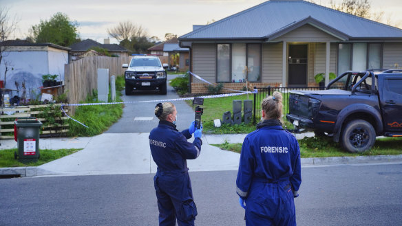 Police outside the scene where two men, a woman and a teenage boy were found dead.