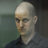 Wall Street Journal reporter Evan Gershkovich stands in a glass cage in a courtroom in Yekaterinburg, Russia.