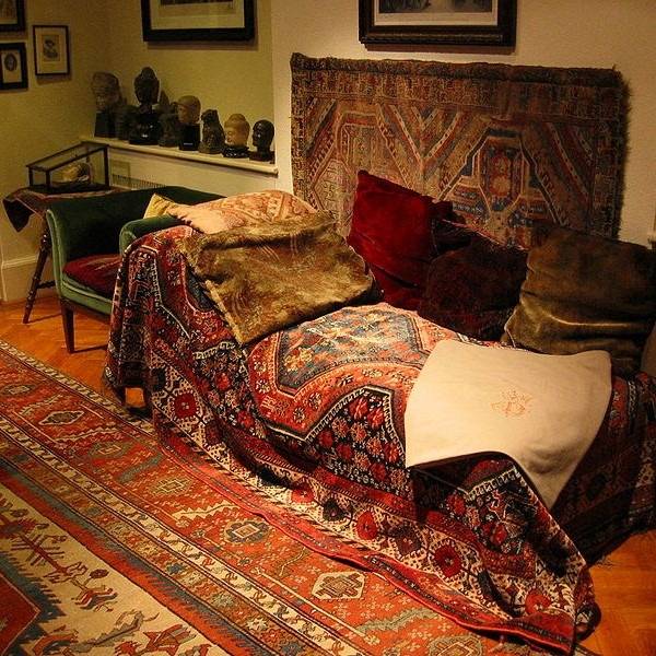 Freud's famous couch, draped in cushions and carpets