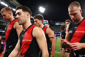 The Bombers look dejected as they leave the field following their loss.